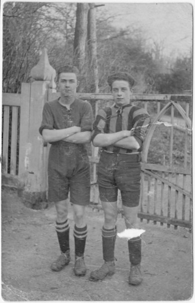 Photo of two footballers by the gate
